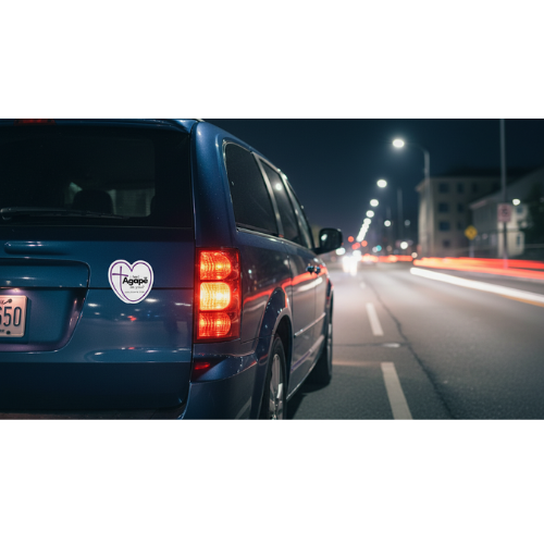 Agapē mission magnet on blue vehicle at night, visible on rear panel